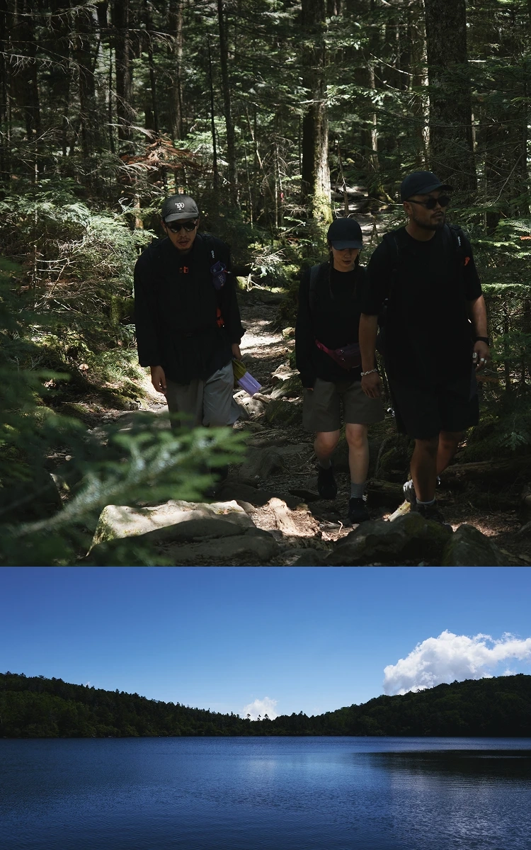 【メインビジュアル】山道を歩く登山客と青空と湖の風景